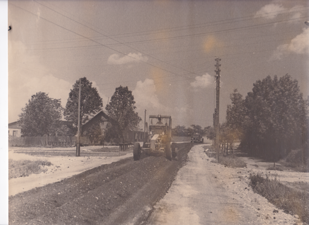 Asfalteerimistööd Tamsalus Paide maanteel 1959. aasta juunis. Greider kaupluse “Areng” ees.