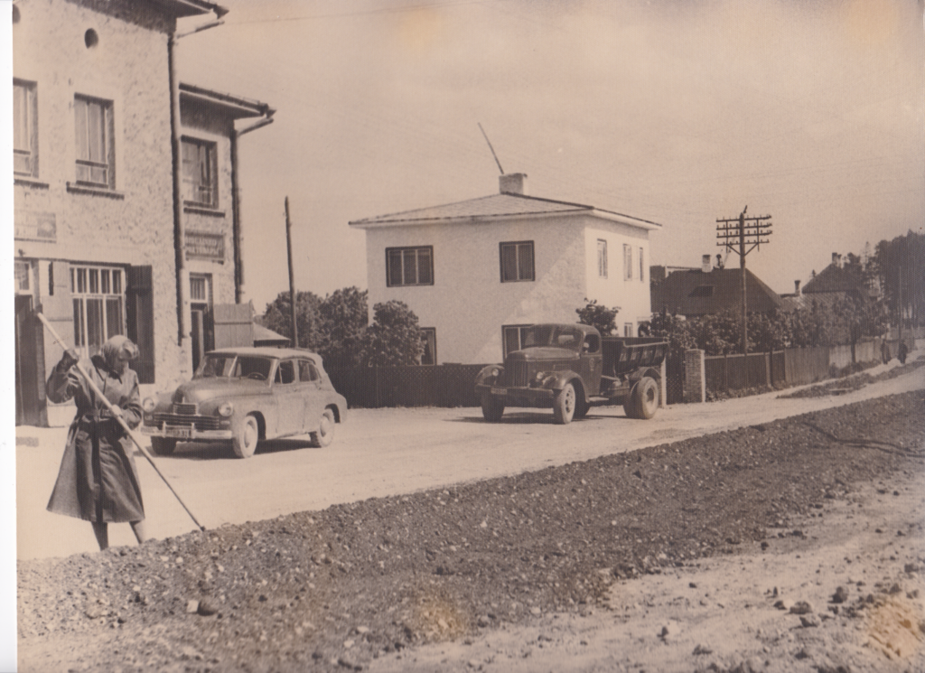 Asfalteerimistööd Kesk tänaval 1959. aasta suvel nn Mürgi poe ees. Pildil on ka Tamsalu teedejaoskonna kontor.